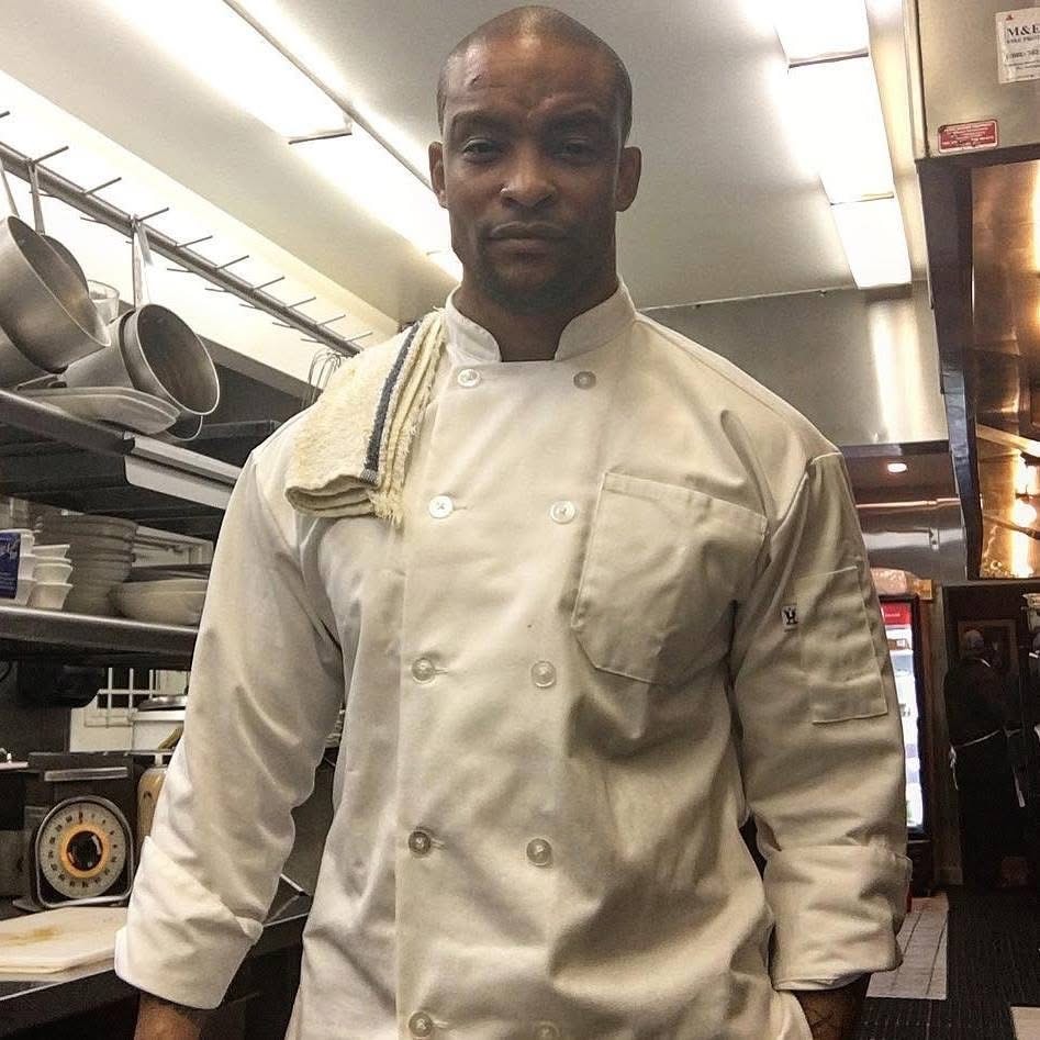 Norman Kai Lee in chef whites in a working kitchen